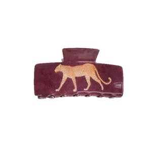 Elegant deep purple leopard print hair claw clip with golden cheetah motif on white background