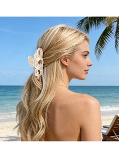 Vue détaillée de la grande pince à cheveux marbrée portée par un mannequin à la plage