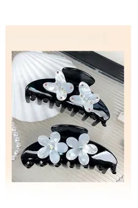 Detail of luxury black hair claw clips with pearl butterfly and crystal flower designs