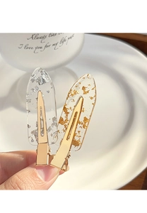 Detailed macro view of transparent resin hair clips with elegant gold and silver foil flakes