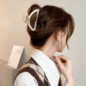 Pince à cheveux demi-lune en perles et boucles d'oreilles argentées sur un mannequin