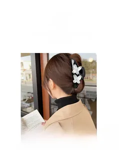 Detail of elegant black and white butterfly hair claw clip with rhinestones and pearls