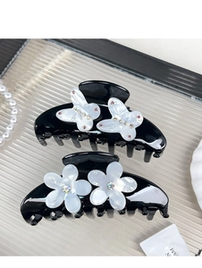 Detail of luxury acetate hair claws with sparkling butterfly and flower crystal motifs