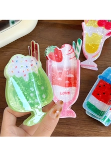 Dettaglio di un fermaglio per capelli a forma di frappè alla fragola con texture colorate