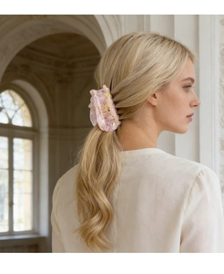 Molla per capelli a forma di gatto rosa con dettagli floreali su capelli biondi