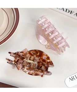 Dettaglio di mollette per capelli in acetato rosa marmorizzato e tartarugato