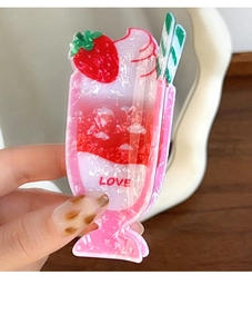 Dettaglio della molletta per capelli a gelato alla fragola con glitter e scritta LOVE