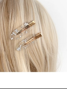 Close-up of transparent acrylic hair clips with silver foil flakes on golden hair