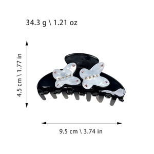 Elegant black acetate hair claw clip with white butterfly design and pink rhinestones