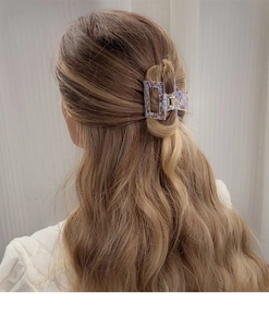 Lavender marble acrylic hair claw clip with geometric hollow design worn on wavy hair