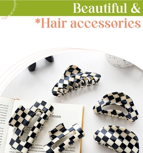 Detail of checkered hair claws with various geometric shapes on a minimalist book background
