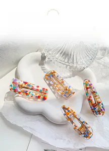 Macro detail of acrylic hair clips with colorful confetti in square and drop shapes