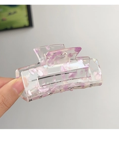 Detail of square acrylic hair claw with purple shell flakes and shimmering texture