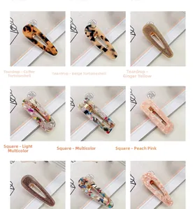 Macro view of acetate hair clips in teardrop and square shapes with gold metal duckbill clips