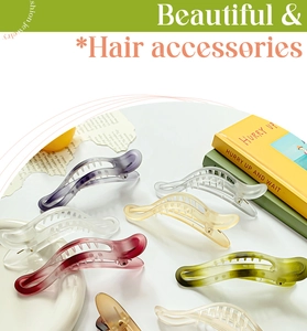 Flat lay of colorful frosted banana hair clips in purple, amber, and green on white desk