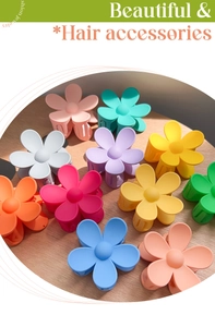 Flat lay of floral hair claws in eleven matte pastel colors on light wood background