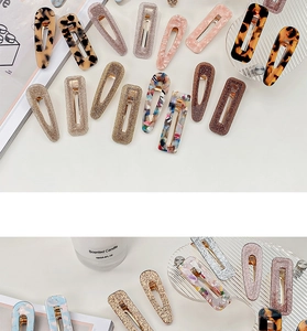 Detail view of acetate hair clips in leopard and marble patterns on a stylish tray