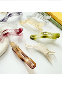 Detail view of large banana hair clips in various gradient colors and matte finishes
