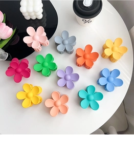 Flat lay of 11 matte macaron flower hair claws with colorful spring garden vibes