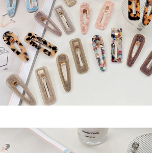 Detailed close-up of acetate hair clips with marble patterns and tortoiseshell textures