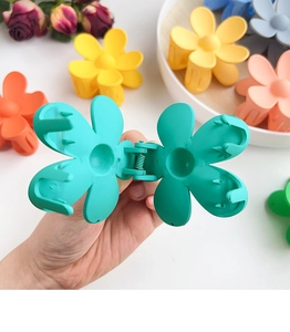 Detail of candy-colored flower hair claw clips with matte finish and non-slip metal spring