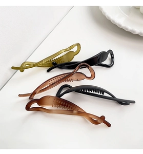 Detail view of five assorted banana hair clips in matte and glossy finishes for women