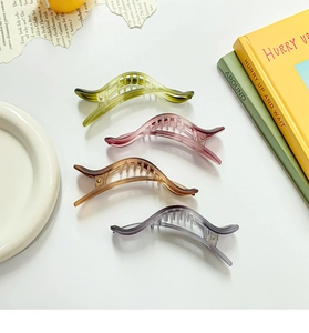 Macro shot of gradient frosted banana clips in four colors with smooth curved design