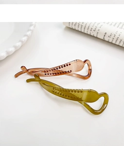 Close-up of translucent brown and green banana hair clips with non-slip teeth detail