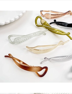 Macro detail of streamlined resin banana hair clips with anti-slip inner teeth design