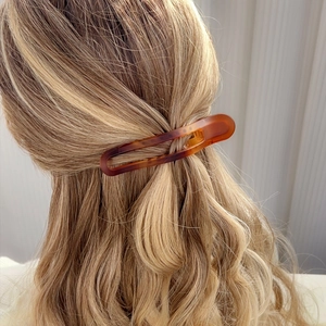 Elegant tortoiseshell hollow barrette in hair on a minimalist light background