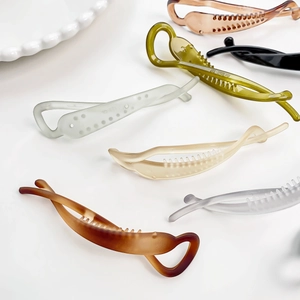 Elegant Korean style banana hair clips in multiple colors on a white decorative plate
