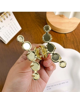 Detailed view of a golden metal hair claw clip featuring a geometric ring design