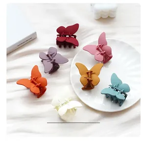 Détails de pinces à cheveux papillon mates en six couleurs Morandi sur tissu blanc élégant