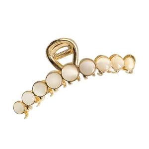 Golden metal hair claw clip with cream white opal stones for an elegant look