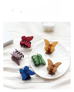 Gros plan de pinces à cheveux papillon mates en six couleurs sur un tissu blanc