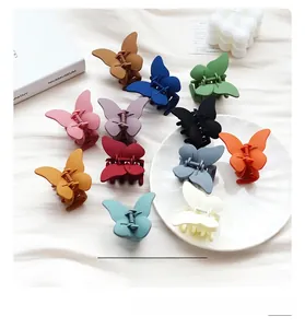 Vue détaillée des pinces à cheveux papillon mates en douze couleurs vives sur tissu