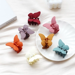 Lot de pinces à cheveux papillon mates en six couleurs sur un fond esthétique
