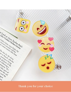 Makroaufnahme süßer gelber Emoji-Acryl-Haarspangen auf einem eleganten Glasständer