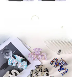 Detail view of wavy acetate hair claws in various marble patterns and pastel colors