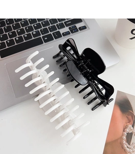 Vue détaillée de pinces à cheveux de 14 cm noir et blanc sur un bureau moderne