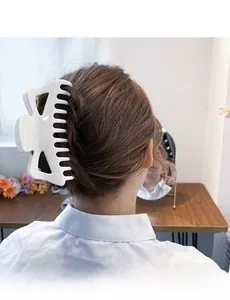 Vue détaillée d'une pince à cheveux blanche de 14cm tenant un chignon élégant