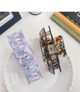 Detail view of 13cm acetate hair claws in marble purple and vintage amber tortoiseshell