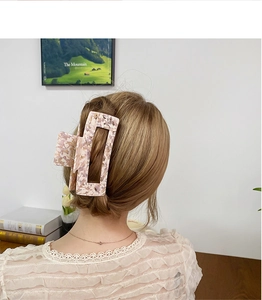 Pink marble acetate hair claw clip styling on long brown hair for large volume hair