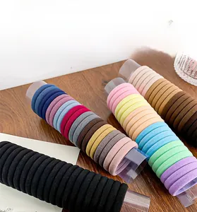 Close-up of multicolor seamless elastic hair ties with ribbed knit texture in a plastic tube