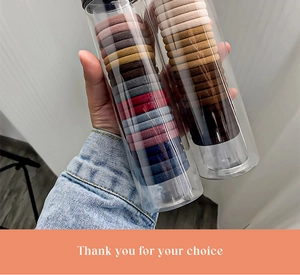 Close-up of assorted colorful thick elastic hair ties in transparent cylindrical jars