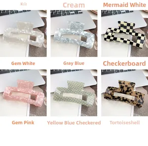 Detail view of 13cm shark hair clips in marble, checkerboard, and tortoiseshell patterns
