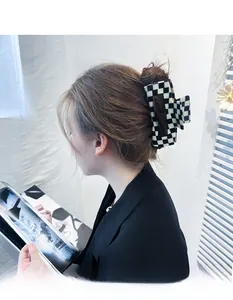 Detail showing a 13cm oversized checkerboard hair claw clip for elegant bun styling