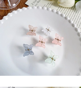 Vue détaillée de six mini pinces à cheveux papillon mates aux tons pastel de macaron