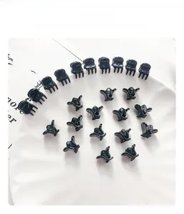 Mini pinces à cheveux noires sur une assiette en céramique pour coiffures variées