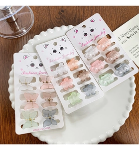 Gros plan de mini pinces à cheveux papillon mates aux tons pastel sur cartes décor